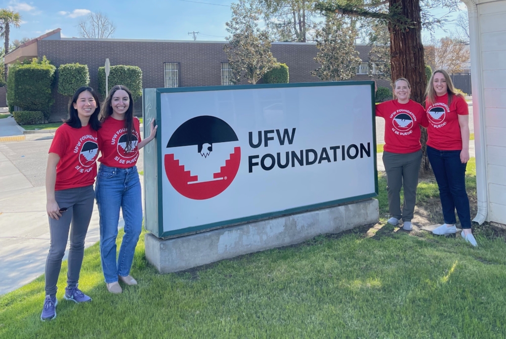 group of students wearing matching t-shirts in front of a sign that says UFW Foundation.