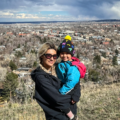 woman and young child outside with a town behind them